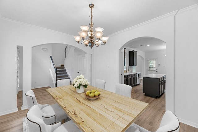 5918 Mahogany Way, Magnolia, TX 77354 - dining space featuring arched walkways, a chandelier, stairs, light wood-type flooring, and ornamental molding