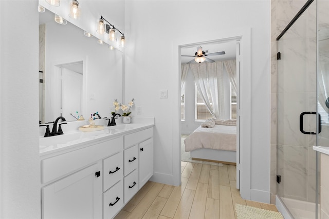 17735 Tree Of Heaven, Conroe, TX 77385 - ensuite bathroom featuring double vanity, a marble finish shower, ceiling fan, and wood finished floors