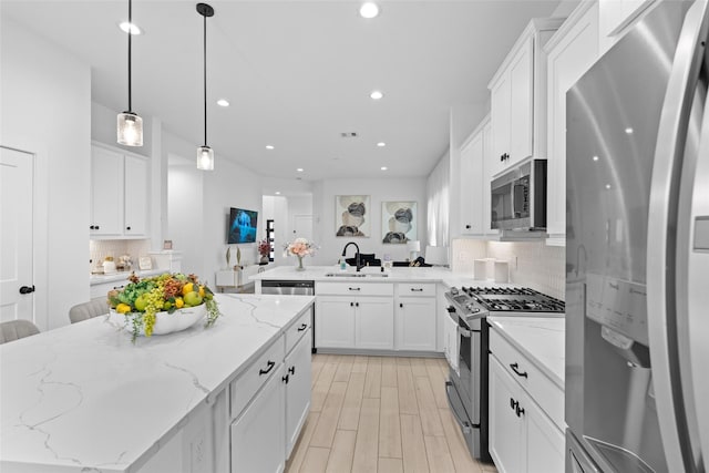 17735 Tree Of Heaven, Conroe, TX 77385 - kitchen with stainless steel appliances, tasteful backsplash, white cabinets, recessed lighting, and decorative light fixtures
