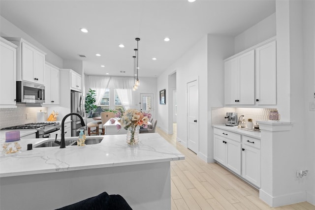 17735 Tree Of Heaven, Conroe, TX 77385 - kitchen featuring stainless steel appliances, recessed lighting, backsplash, white cabinetry, and hanging light fixtures