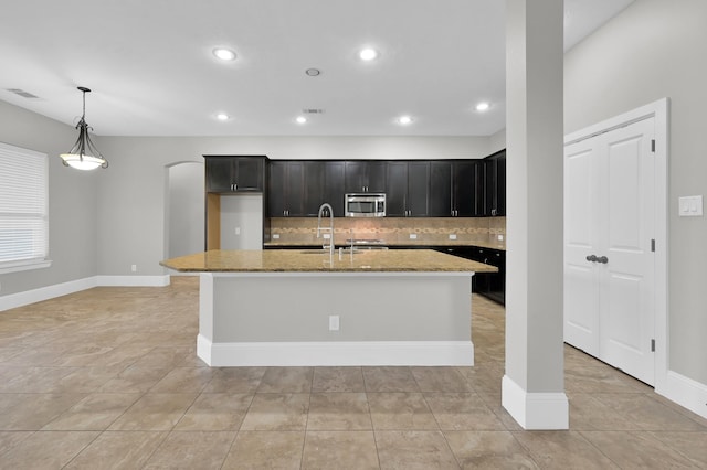 18618 Bridle Grove Ct, Tomball, TX 77377 - kitchen featuring stainless steel microwave, backsplash, light stone counters, light tile patterned flooring, and recessed lighting