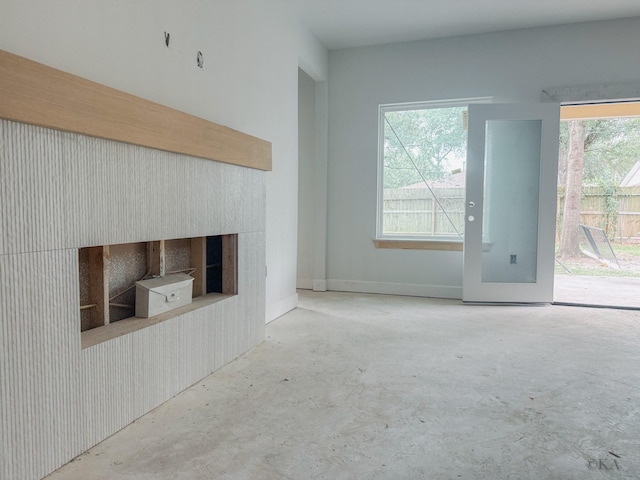 10651 Mayfield Rd, Houston, TX 77043 - unfurnished living room featuring unfinished concrete floors, plenty of natural light, and a fireplace