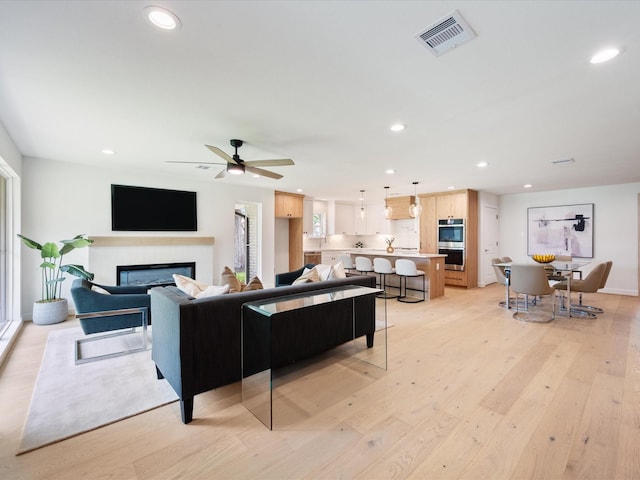 10651 Mayfield Rd, Houston, TX 77043 - living room featuring recessed lighting, light wood-style floors, a glass covered fireplace, and ceiling fan