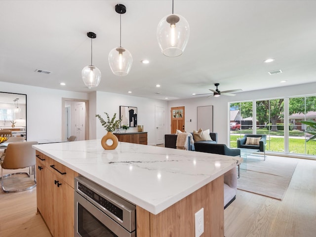10651 Mayfield Rd, Houston, TX 77043 - kitchen featuring open floor plan, a center island, recessed lighting, light wood-type flooring, and a ceiling fan