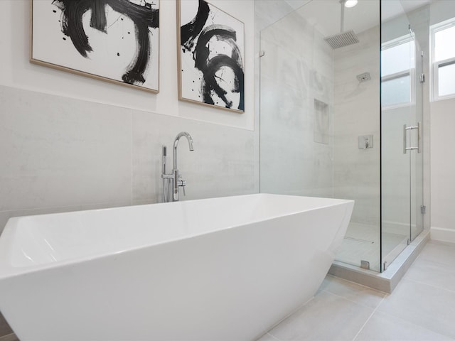 10651 Mayfield Rd, Houston, TX 77043 - bathroom featuring a shower stall, tile patterned flooring, and a freestanding tub
