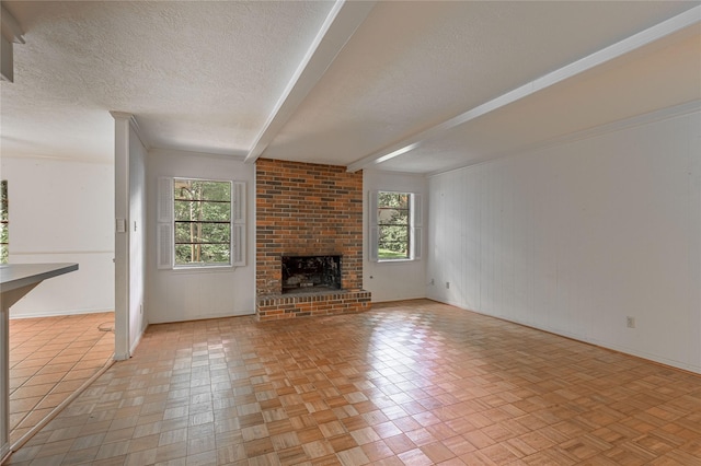 3799 Summer Ln, Huntsville, TX 77340 - unfurnished living room featuring plenty of natural light, a textured ceiling, beam ceiling, and a fireplace