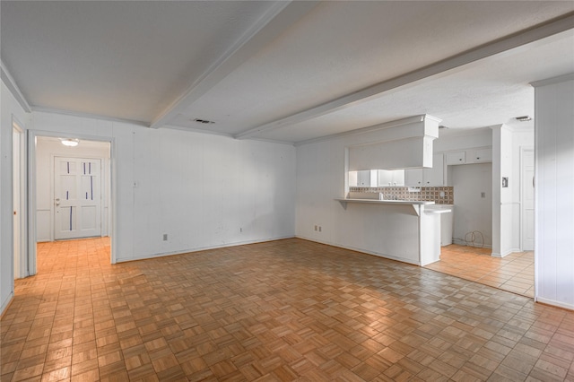 3799 Summer Ln, Huntsville, TX 77340 - unfurnished living room featuring beamed ceiling and baseboards