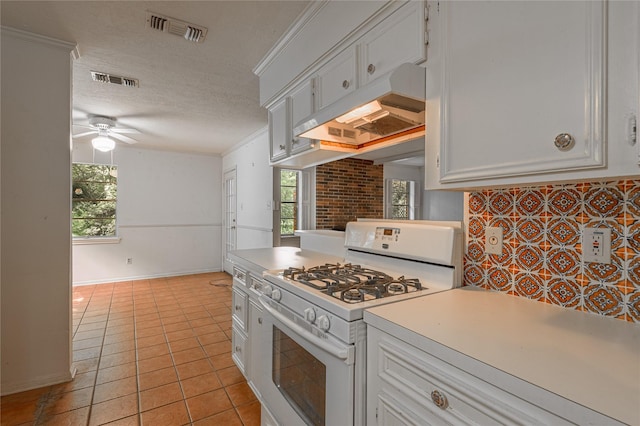3799 Summer Ln, Huntsville, TX 77340 - kitchen with white range with gas cooktop, under cabinet range hood, a ceiling fan, light countertops, and light tile patterned floors