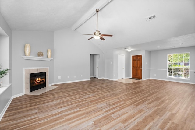 14306 Cypress Meadow Dr, Cypress, TX 77429 - unfurnished living room with ceiling fan, a tiled fireplace, light wood-style floors, beamed ceiling, and high vaulted ceiling