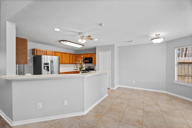 14306 Cypress Meadow Dr, Cypress, TX 77429 - kitchen with appliances with stainless steel finishes, light countertops, light tile patterned floors, a ceiling fan, and a textured ceiling