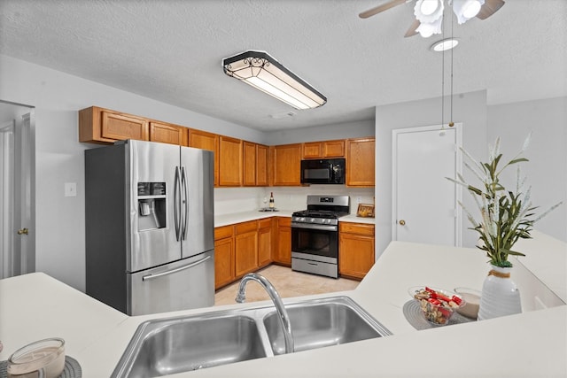 14306 Cypress Meadow Dr, Cypress, TX 77429 - kitchen with appliances with stainless steel finishes, light countertops, a ceiling fan, brown cabinets, and a textured ceiling