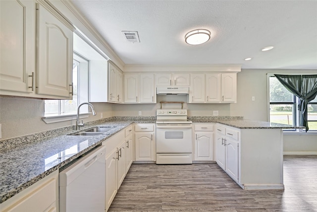 2131 6th Ave N, Texas City, TX 77590 - kitchen with white appliances, under cabinet range hood, a peninsula, wood finished floors, and recessed lighting