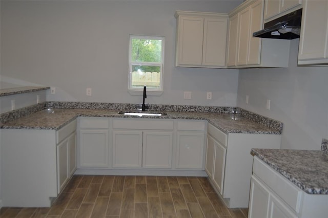 327 Delaware St Unit A, Houston, TX 77029 - kitchen with under cabinet range hood, stone counters, white cabinetry, and wood finished floors