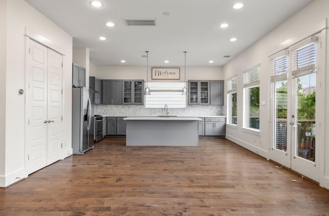 406 Yale Oaks Ln, Houston, TX 77091 - kitchen with gray cabinetry, stainless steel appliances, recessed lighting, glass insert cabinets, and decorative backsplash