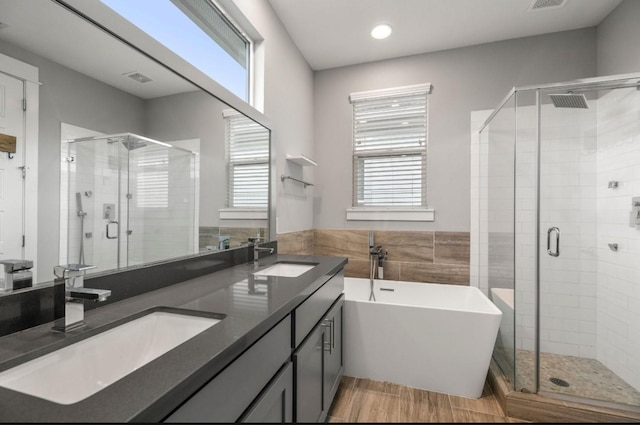 406 Yale Oaks Ln, Houston, TX 77091 - full bathroom with a shower stall, a freestanding tub, double vanity, recessed lighting, and wood finished floors
