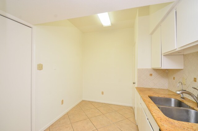 2100 Tanglewilde St Unit 169, Houston, TX 77063 - kitchen with light tile patterned floors, light countertops, white cabinets, and tasteful backsplash