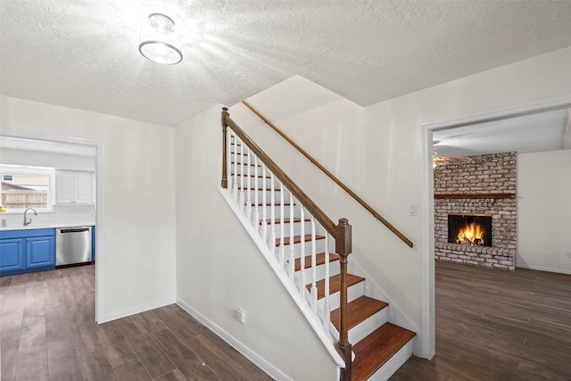 8114 Coolshire Ln, Houston, TX 77070 - staircase featuring wood finished floors, a textured ceiling, and a brick fireplace
