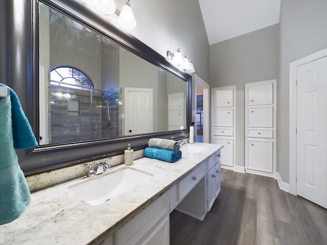 11614 Taos Ln, Houston, TX 77070 - bathroom with double vanity, wood finished floors, a shower stall, and high vaulted ceiling