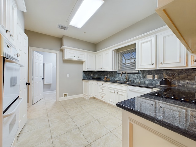11614 Taos Ln, Houston, TX 77070 - kitchen featuring tasteful backsplash, dark stone countertops, white appliances, and white cabinetry