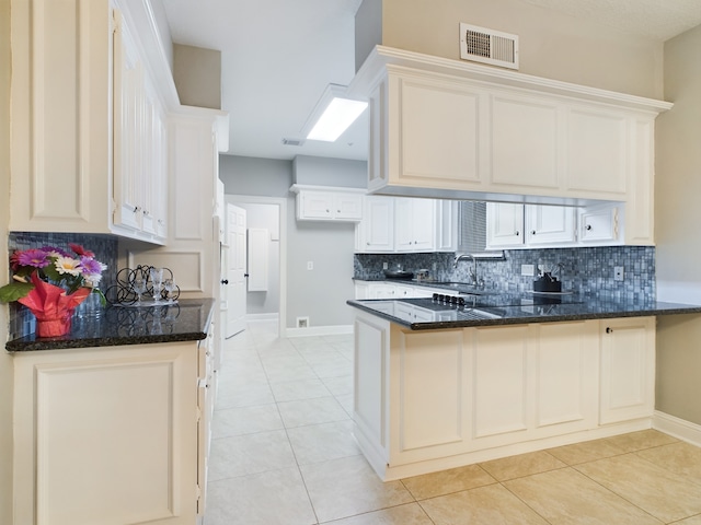11614 Taos Ln, Houston, TX 77070 - kitchen featuring a peninsula, decorative backsplash, dark stone countertops, and light tile patterned flooring