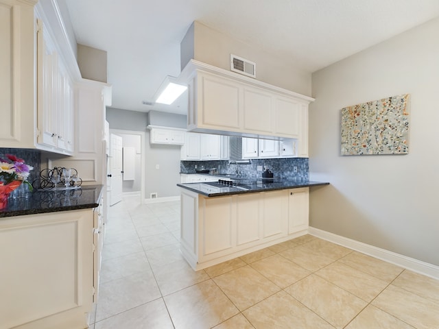 11614 Taos Ln, Houston, TX 77070 - kitchen with a peninsula, decorative backsplash, light tile patterned flooring, dark stone counters, and white cabinetry