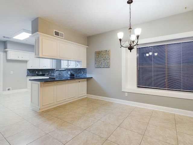 11614 Taos Ln, Houston, TX 77070 - kitchen with a peninsula, backsplash, a chandelier, light tile patterned floors, and white cabinetry