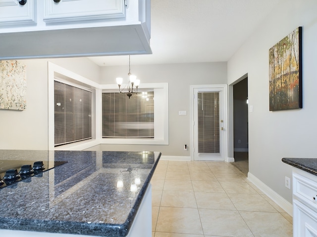 11614 Taos Ln, Houston, TX 77070 - kitchen with white cabinets, light tile patterned floors, a chandelier, dark stone counters, and hanging light fixtures