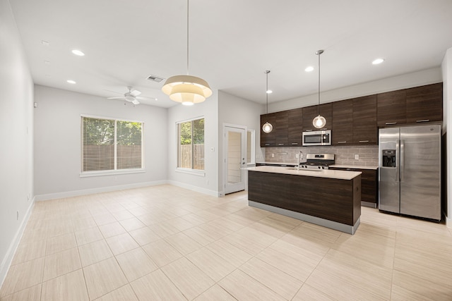 1907 Harlem St Unit A, Houston, TX 77020 - kitchen with appliances with stainless steel finishes, light countertops, decorative backsplash, dark brown cabinetry, and recessed lighting