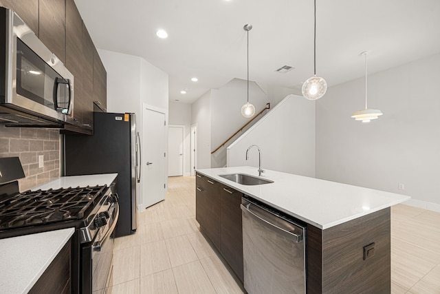 1907 Harlem St Unit A, Houston, TX 77020 - kitchen featuring stainless steel appliances, modern cabinets, dark brown cabinets, backsplash, and an island with sink