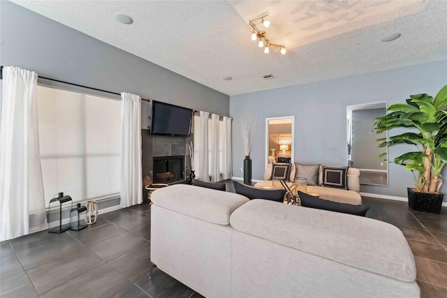 1710 Blue Heather Ln, Fresno, TX 77545 - living room featuring a textured ceiling, a fireplace, and dark tile patterned floors