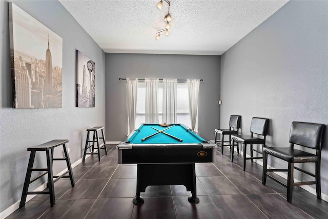 1710 Blue Heather Ln, Fresno, TX 77545 - recreation room with billiards, a textured ceiling, a textured wall, rail lighting, and dark tile patterned flooring