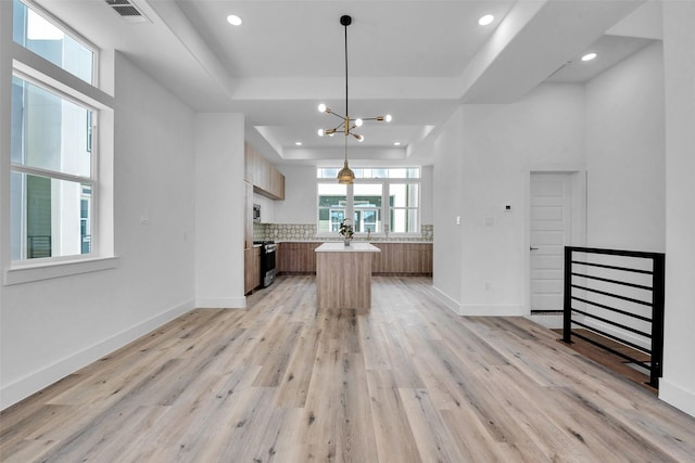 1805 Emir St Unit E, Houston, TX 77009 - kitchen with a raised ceiling, appliances with stainless steel finishes, a kitchen island, light wood-style flooring, and light countertops