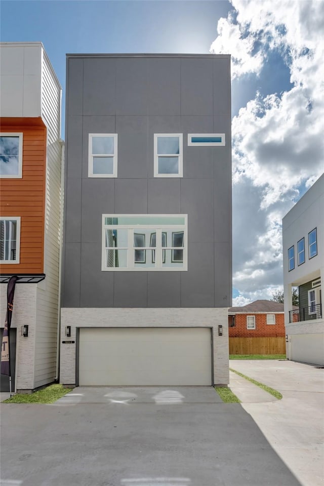 1805 Emir St Unit E, Houston, TX 77009 - view of front facade with an attached garage, driveway, and stucco siding