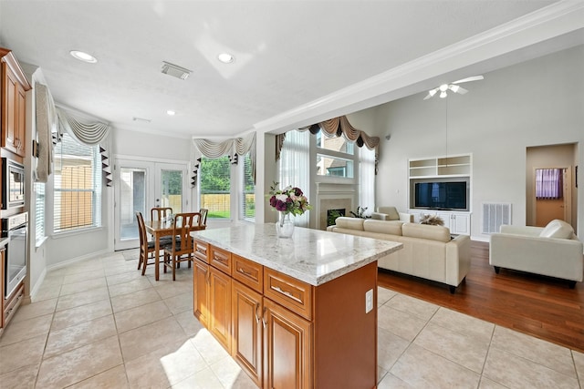 21306 Willowford Park Dr, Katy, TX 77450 - kitchen featuring light tile patterned flooring, crown molding, light stone countertops, a fireplace, and recessed lighting