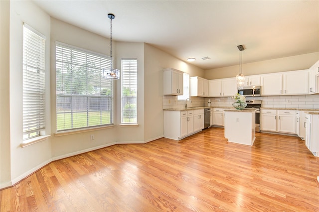 21306 Branford Hills Ln, Katy, TX 77450 - kitchen featuring stainless steel appliances, backsplash, light wood-style floors, and a center island
