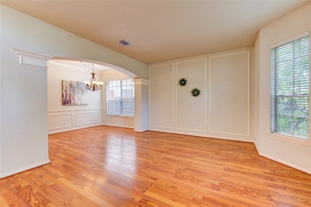 21306 Branford Hills Ln, Katy, TX 77450 - unfurnished room with a decorative wall, arched walkways, a chandelier, light wood-style flooring, and decorative columns
