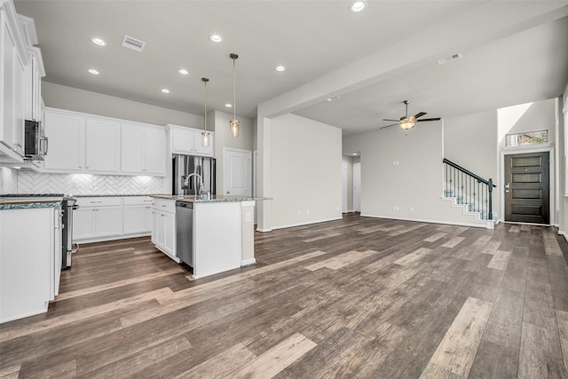 16114 Northern Cardinal Ln, Cypress, TX 77433 - kitchen featuring appliances with stainless steel finishes, open floor plan, tasteful backsplash, an island with sink, and ceiling fan