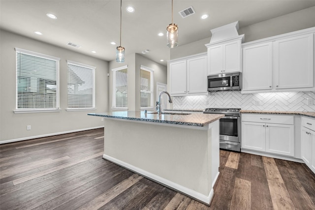 16114 Northern Cardinal Ln, Cypress, TX 77433 - kitchen with appliances with stainless steel finishes, backsplash, light stone counters, a center island with sink, and white cabinets