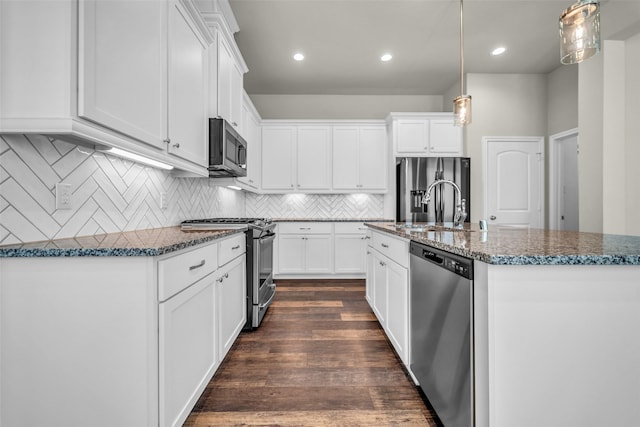 16114 Northern Cardinal Ln, Cypress, TX 77433 - kitchen featuring stainless steel appliances, dark stone countertops, white cabinetry, an island with sink, and recessed lighting