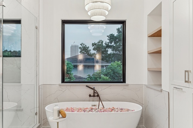 1310 Willard, Houston, TX 77006 - bathroom featuring tile walls, a freestanding bath, a marble finish shower, and built in shelves