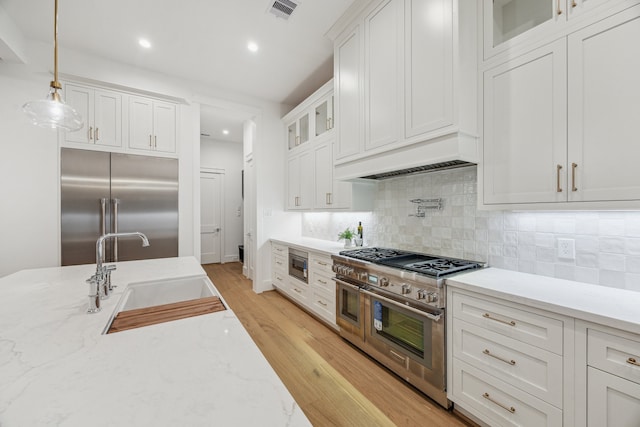 1310 Willard, Houston, TX 77006 - kitchen featuring built in appliances, white cabinetry, decorative backsplash, light wood-style flooring, and recessed lighting