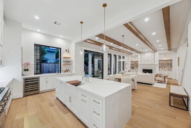 1310 Willard, Houston, TX 77006 - kitchen featuring wine cooler, recessed lighting, light wood-style floors, white cabinets, and beamed ceiling
