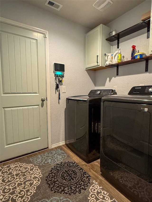 706 Zinnia Ct, Rosharon, TX 77583 - laundry area featuring washer and clothes dryer, cabinet space, wood finished floors, and a textured wall