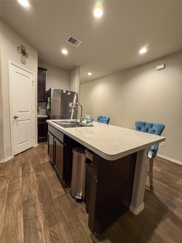 706 Zinnia Ct, Rosharon, TX 77583 - kitchen featuring freestanding refrigerator, dark wood-type flooring, light countertops, a kitchen island with sink, and recessed lighting