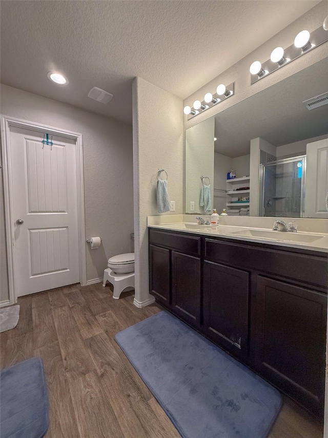 706 Zinnia Ct, Rosharon, TX 77583 - bathroom with wood finished floors, double vanity, a shower stall, and a textured ceiling