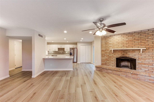 22843 Post Gate Dr, Spring, TX 77373 - unfurnished living room featuring light wood finished floors, recessed lighting, a brick fireplace, and ceiling fan