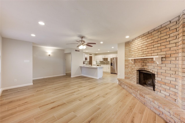 22843 Post Gate Dr, Spring, TX 77373 - unfurnished living room with recessed lighting, a brick fireplace, light wood-style flooring, and ceiling fan