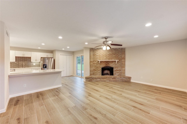 22843 Post Gate Dr, Spring, TX 77373 - unfurnished living room with ceiling fan, light wood-style floors, recessed lighting, and a fireplace