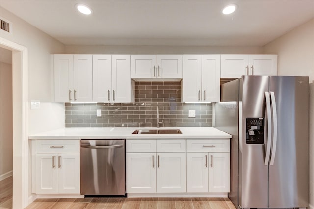 22843 Post Gate Dr, Spring, TX 77373 - kitchen featuring stainless steel appliances, light countertops, white cabinets, and recessed lighting