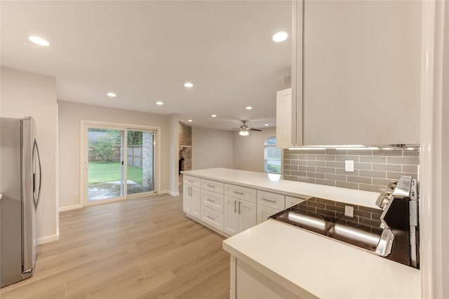 22843 Post Gate Dr, Spring, TX 77373 - kitchen featuring freestanding refrigerator, a brick fireplace, tasteful backsplash, recessed lighting, and a ceiling fan